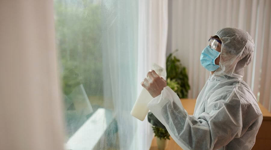 Pest control technician treating a San Antonio home for ants and roaches